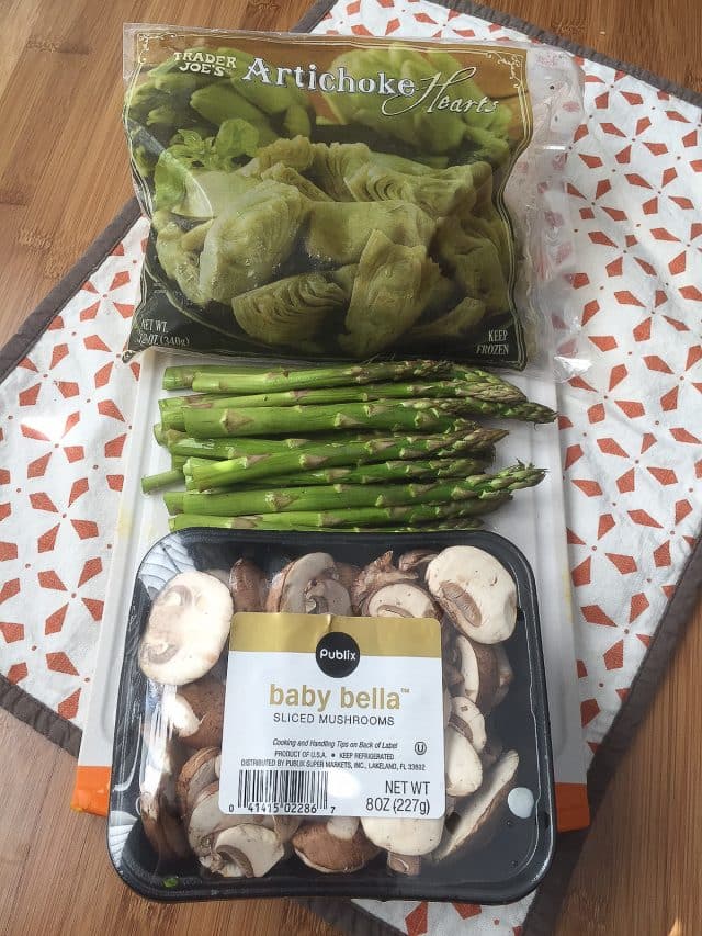 bag of frozen artichoke hearts, asparagus spears, and container of baby bella sliced mushrooms