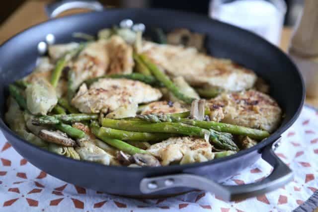 skillet with chicken, artichokes, mushrooms, and asparagus