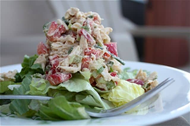 plate with fork and chicken salad topped on a bed of greens