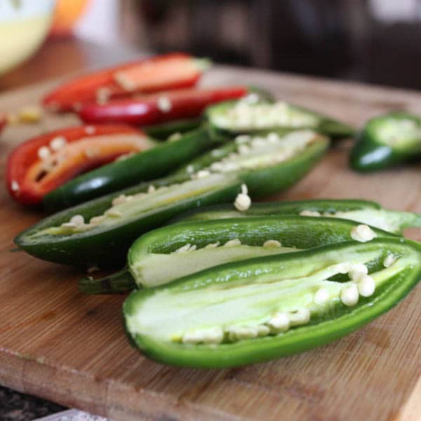 fresh jalapenos cut in half with seeds showing