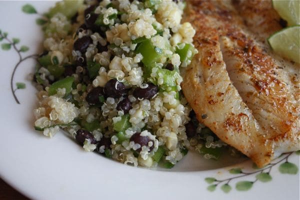 plate of cooked fish with a side of quinoa, black bean, and corn salad