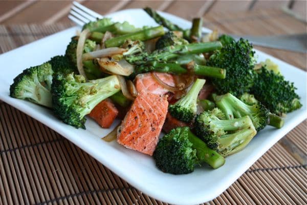 plate of broccoli, asparagus, onions, and salmon mixed together