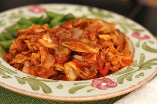 stuffed cabbage casserole in a bowl alongside green beans