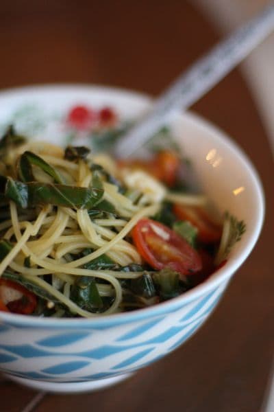 A quick and healthy Quinoa Spaghetti with Garlicky Greens and Tomatoes dish for a vegetarian option at dinner.