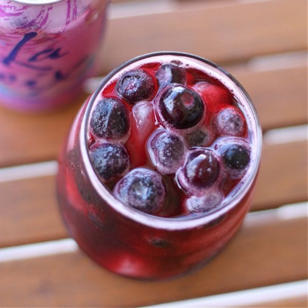 overhead of wine glass with red wine and sparkling water with blueberries