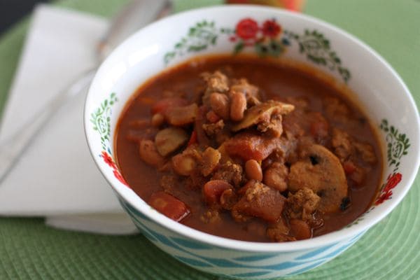 bowl of ground turkey chili with pinto beans, mushrooms, and tomato chunks