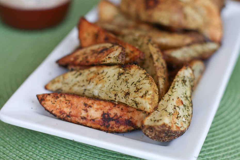 roasted potato wedges with dill on white plate
