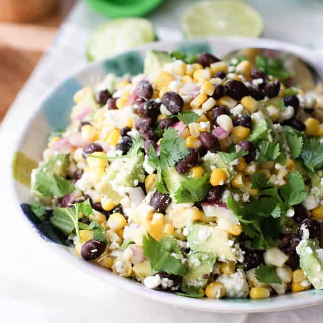 fresh corn, black bean and avocado with cilantro in a salad bowl