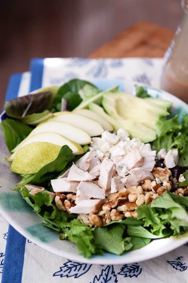 close up of salad with chopped rotisserie chicken, walnuts and sliced pears and avocado