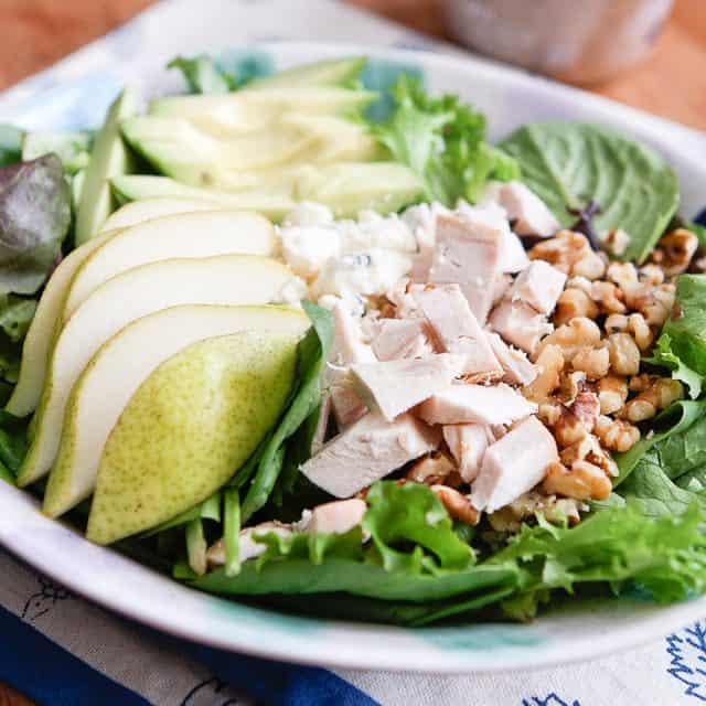 close up of salad with pears, chopped rotisserie chicken, walnuts and avocado