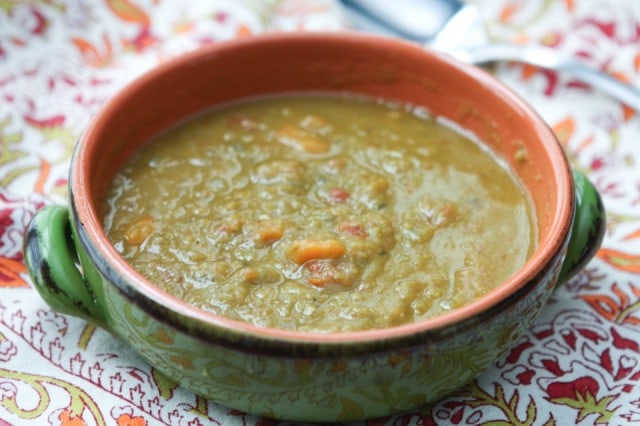 bowl of split pea soup on fall colored table napkin with spoon in background