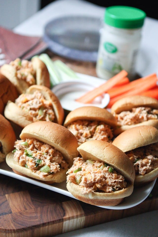 plate of chicken salad sliders in buns alongside carrot and celery sticks with a cup of ranch