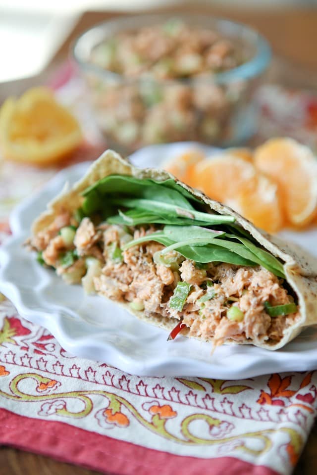 plate of half of a pita stuffed with salmon salad and spinach leaves