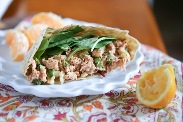 plate of half of a pita stuffed with salmon salad and spinach leaves