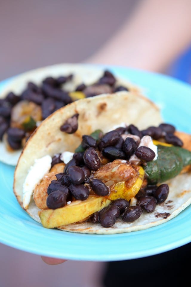 plate of two tortillas with chicken, squash, and topped with black beans