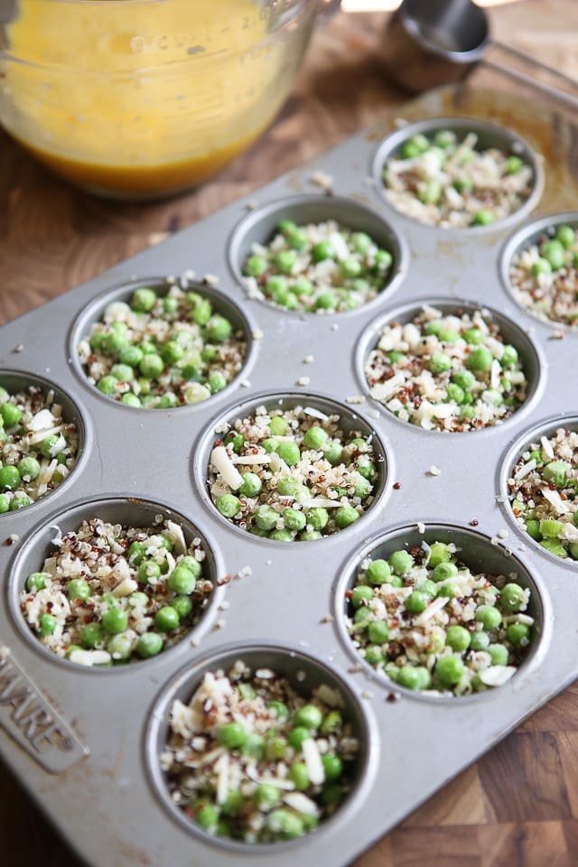 muffin tin filled with quinoa, peas and cheese mixture before adding eggs