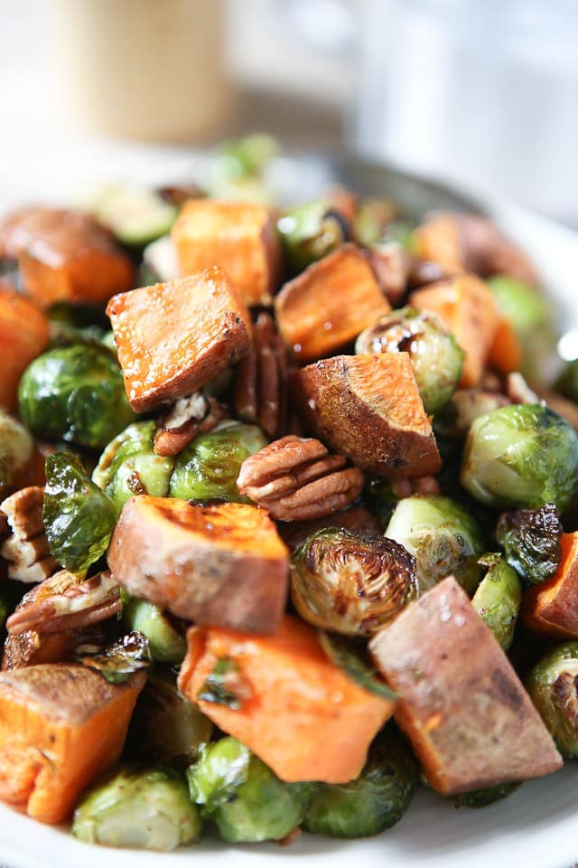 All the flavors of fall on a plate! Drizzled with a maple, balsamic and sriracha glaze....you'll love these Roasted Sweet Potatoes and Brussels Sprouts with Pecans #ThinkFisher