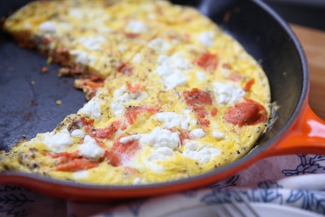 skillet with cooked egg loaded with cheese and salmon