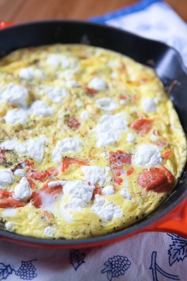 skillet with cooked egg loaded with cheese and salmon