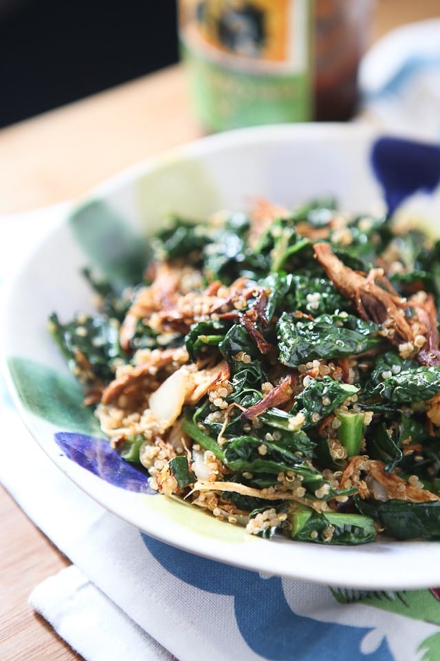 bowl of quinoa topped with shredded bbq chicken and kale