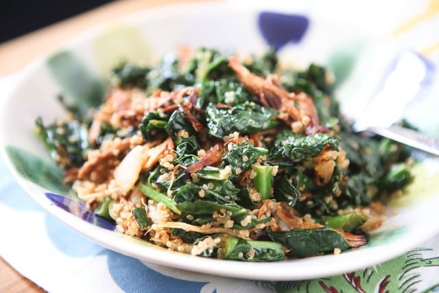 bowl of quinoa topped with shredded bbq chicken and kale