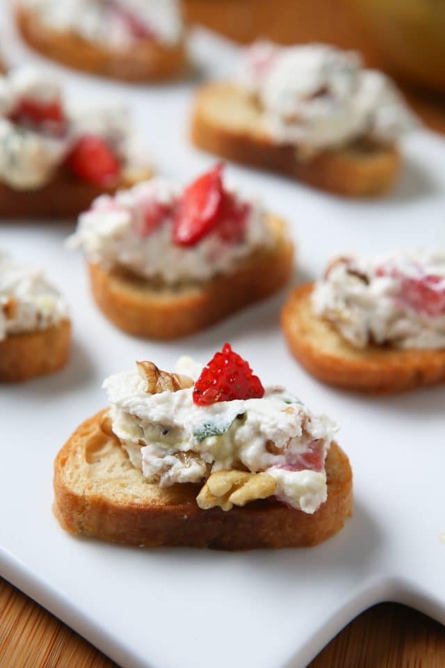 snack toast with strawberry goat cheese spread on white platterS