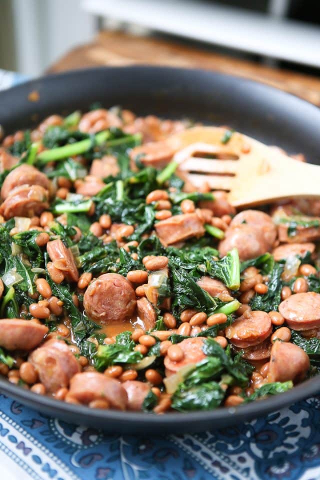 skillet with baked beans, kale, and sausage
