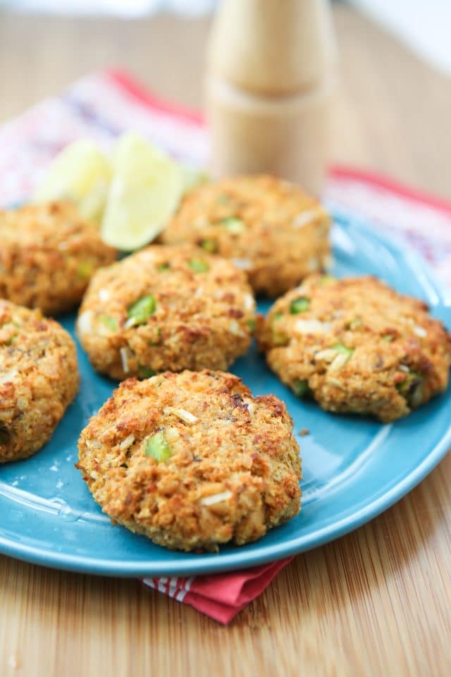 baked salmon cakes on blue plate with pepper mill in the background