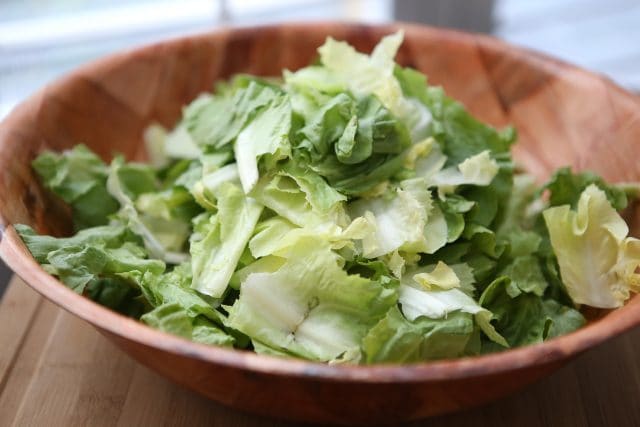 large wooden bowl full of chopped romaine lettuce