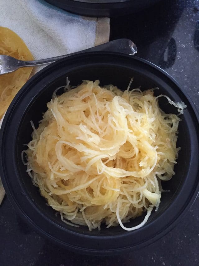 black meal prep container filled with cooked spaghetti squash