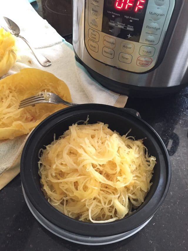 meal prep bowl filled with cooked spaghetti squash with instant pot on counter