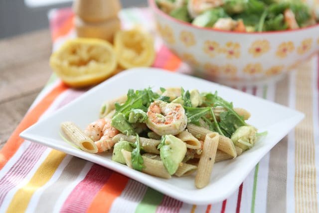 plate of whole wheat pasta topped with shrimp, arugula, and diced avocado