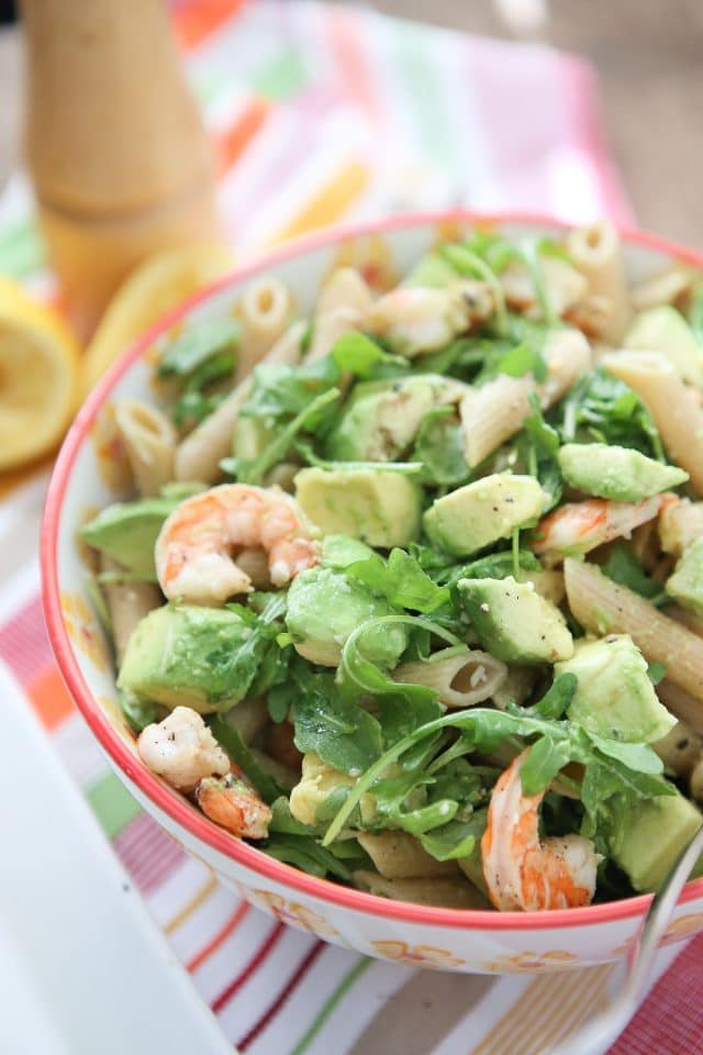 plate of whole wheat pasta topped with shrimp, arugula, and diced avocado