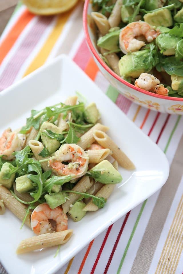 plate of whole wheat pasta topped with shrimp, arugula, and diced avocado