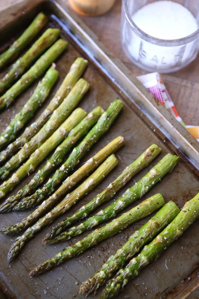 roasted asparagus on a sheet pan with salt and pepper