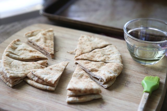 pita bread cut into triangles on a cutting board