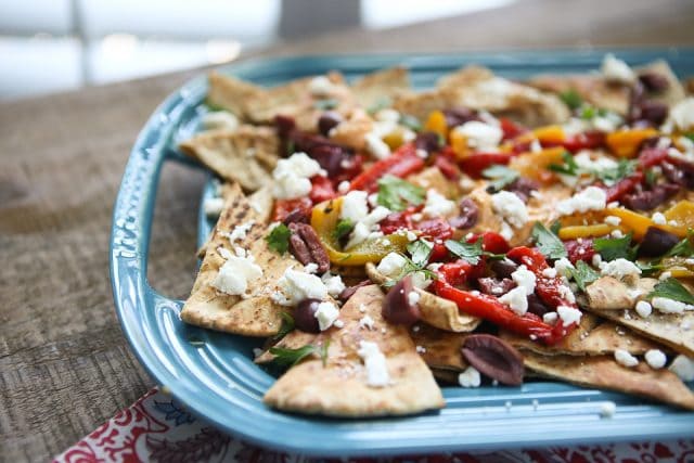 Say hello to your new favorite appetizer! Mediterranean Nachos with Roasted Red Pepper Hummus is what you could call a beautiful mess of all the flavors I love in this world. Topped with Sabra Hummus, roasted peppers, olives, feta and fresh herbs, you can't go wrong with this one! Recipe via aggieskitchen.com