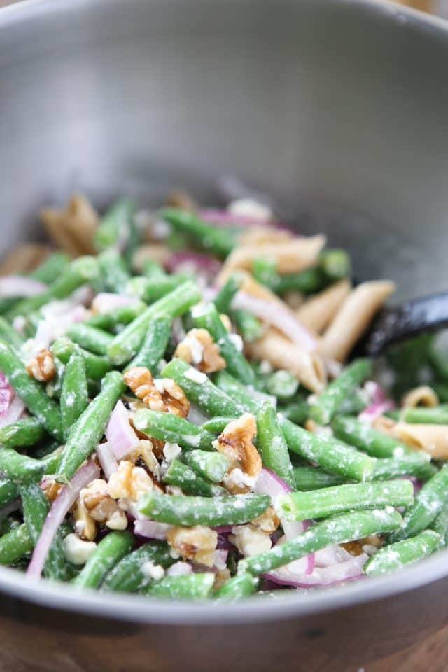 green beans with walnuts, feta and red onion in a bowl