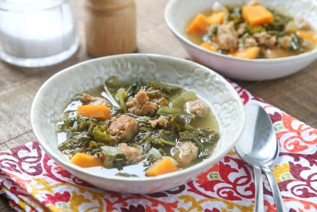 bowl of Italian sausage and kale soup on a colorful napkin with spoon