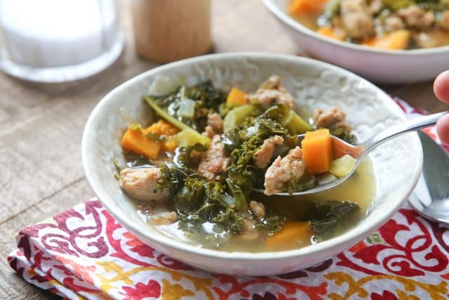 bowl of sausage and kale soup with spoon