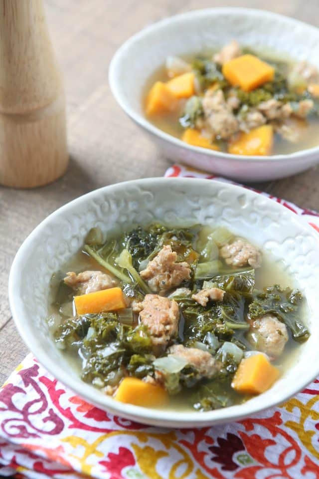 2 bowls of sausage kale soup and pepper mill