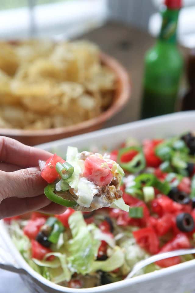 This Layered Taco Dip is full of all the ingredients that we love in our tacos, but in dip form. Great to serve while entertaining family and friends! #UndeniablyDairy #DairyGood #ad