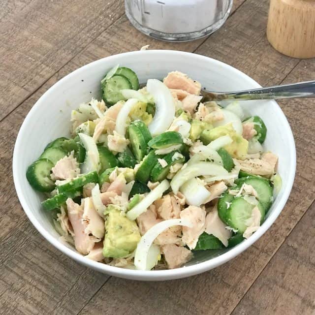 Salad mentimun, alpukat, dan bawang bombay dengan tuna dalam mangkuk putih